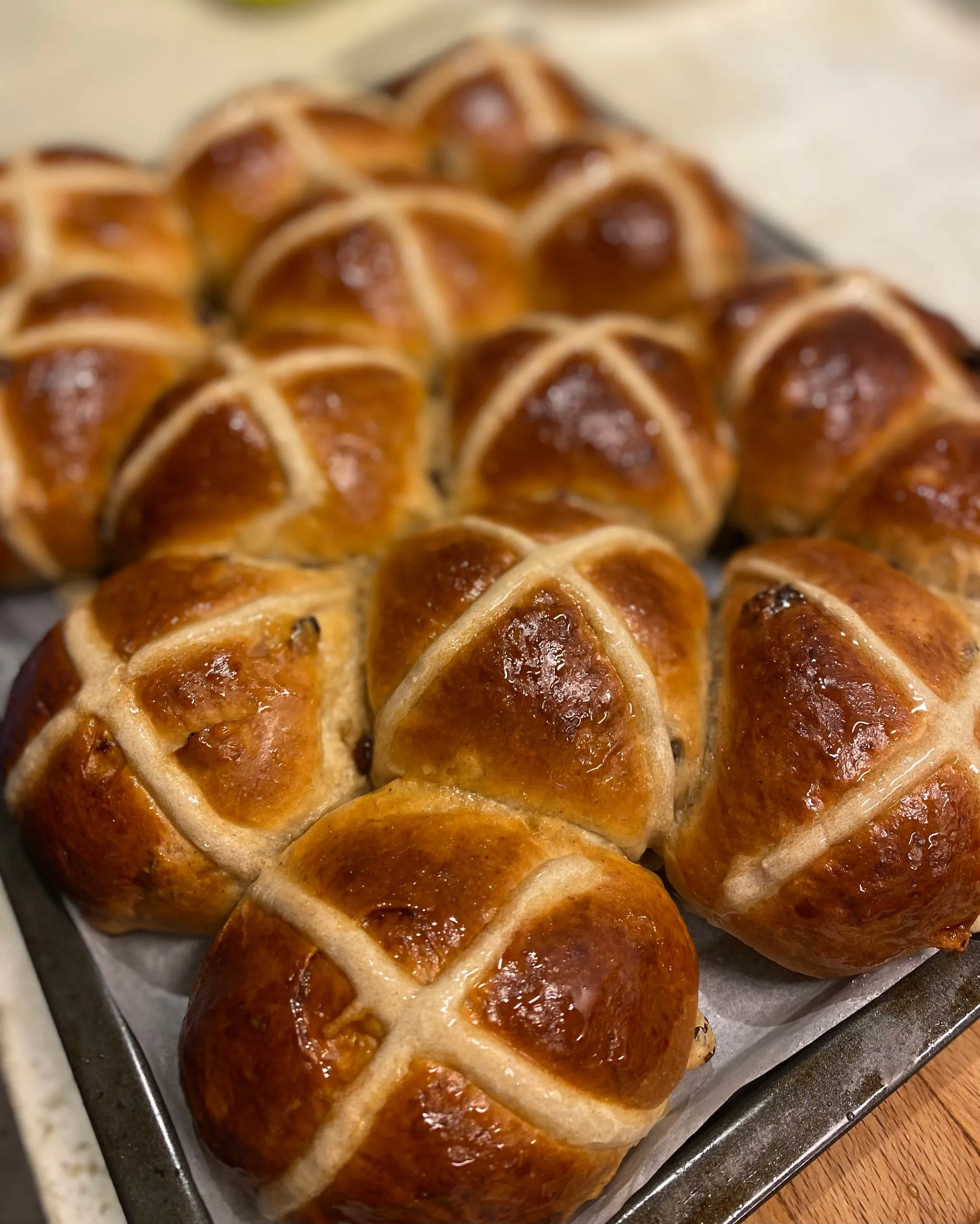 A tray of glazed hot cross buns, fresh from the oven