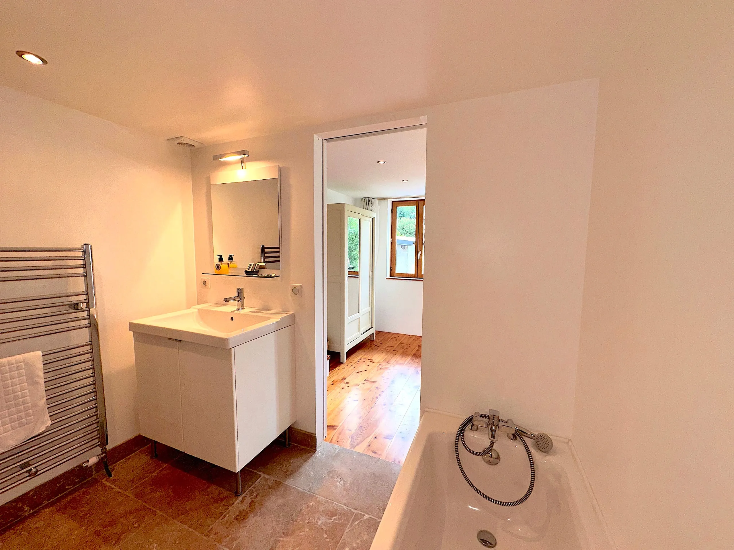 The ensuite bathroom of bedroom two, with a bath and a heated towel rail