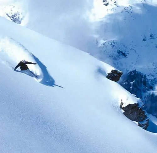 A snowboarder throwing up fresh powder