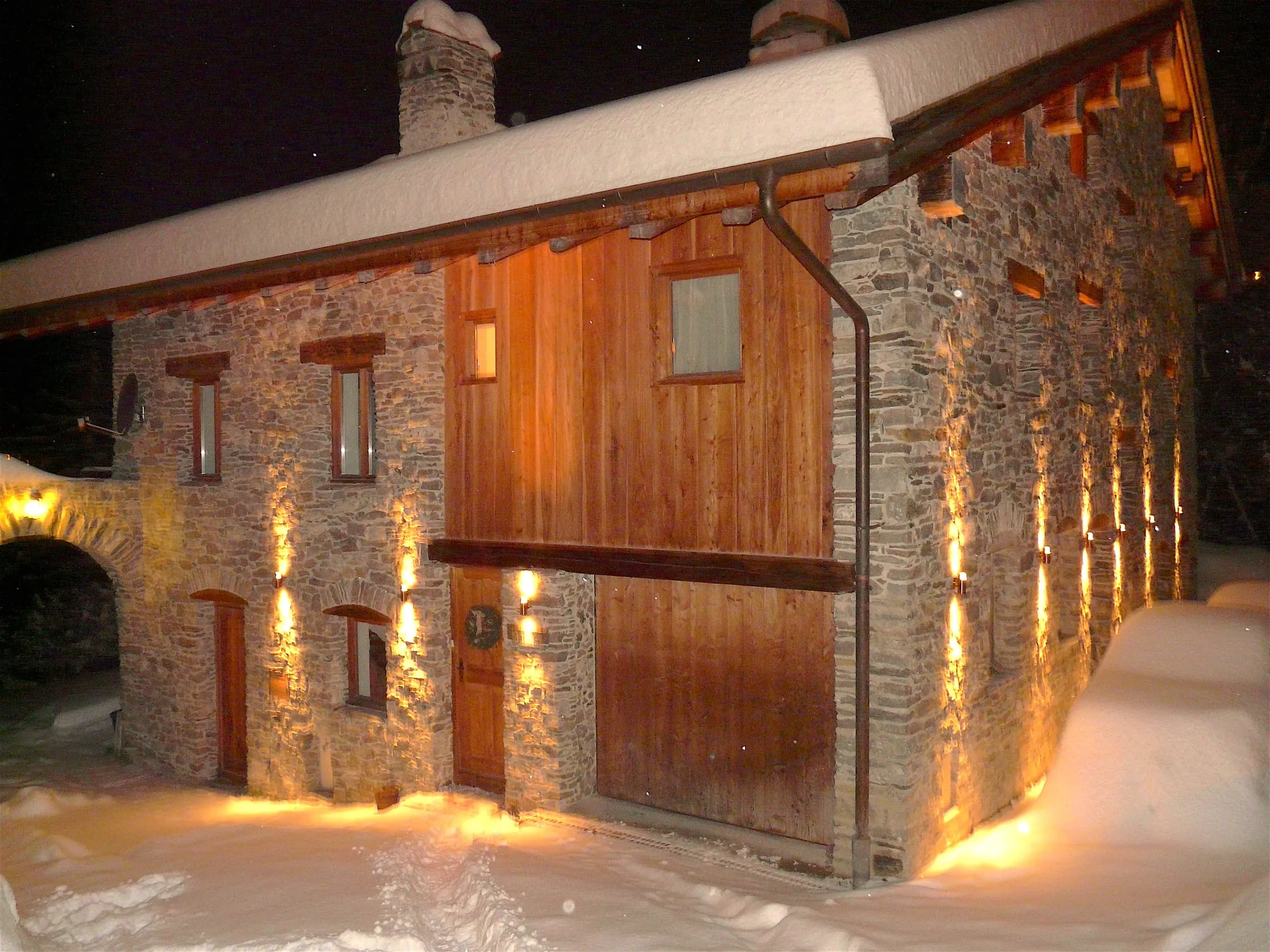The chalet entrance lit up on a snowy night