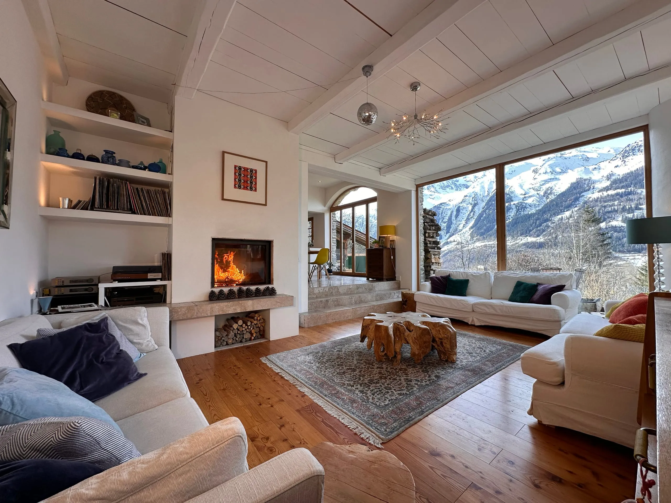 The lounge at La Tillette, sofas facing a floor-to-ceiling window onto snow-covered mountains